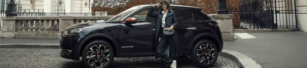 femme devant une voiture noir dans la rue