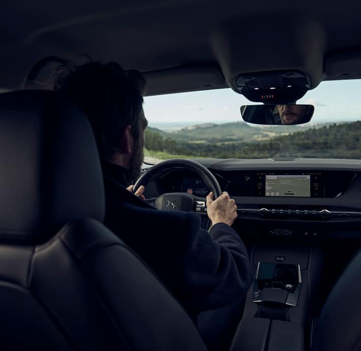 homme qui roule au volant d'une berline premium DS4