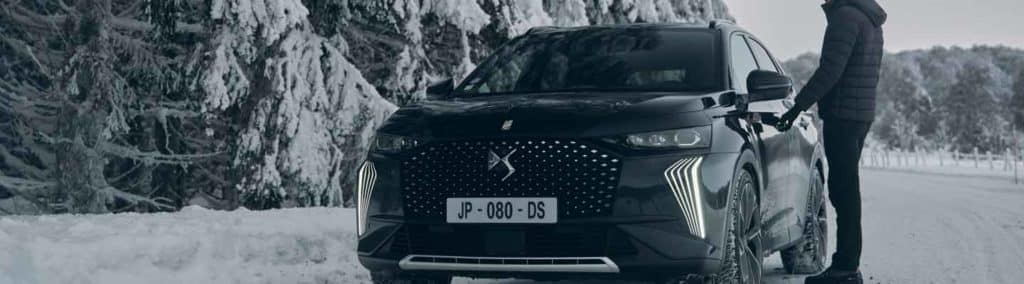 Voiture noir dans la neige avec homme debout